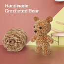 Handmade crocheted bear next to a ball of yarn on a pink background