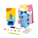 Crocheted blue dragon toy with packaging and accessories on a white background