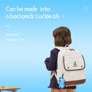 Person wearing a white backpack with a dinosaur charm on a blue background