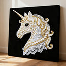 Decorative unicorn wall art with pearls and gold accents on a black background
