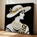 Canvas art of a woman's profile wearing a pearl-studded hat and necklace on a black background.