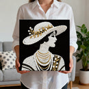 Person holding a framed artwork of a stylized portrait with decorative elements.