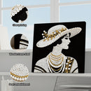 Decorative wall art of a woman wearing a pearl-studded hat and jewelry, with close-up details of pearls and wooden frame.