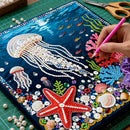 Handmade artwork with bead decorations of jellyfish, starfish, and other sea creatures on a blue background.