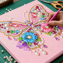 Colorful butterfly design being embellished with beads on a pink surface.