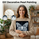 Woman holding a completed DIY decorative pearl painting of a butterfly, with materials shown above her.
