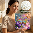Woman holding a diamond painting kit with a butterfly design, surrounded by pearls of different sizes.