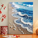 Canvas painting of a beach scene with waves and sand on a wall.