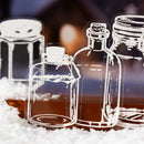 Decorative glass bottles with snow on a blurred background