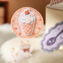 Felt ice cream cone ornament on a soft surface with a blurred background