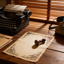 Vintage typewriter and phone on a wooden desk with decorative paper and stamp.