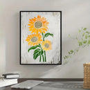 Framed artwork of sunflowers on a wall above a desk.