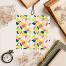 Colorful geometric patterned paper on a surface with books and flowers.