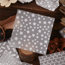 Gray paper with star pattern on a wooden surface with decorative items.