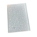 A clear plastic sheet covered with a dense pattern of small white star and starburst motifs, photographed on a plain white background.