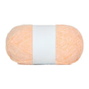 Ball of peach-colored yarn with a white label on a white background