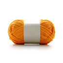 Orange yarn ball with a white label on a white background