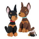 Two crocheted dog toys, one black and brown and the other brown and black, with accessories on a white background.