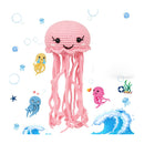 Pink crochet jellyfish toy with small ocean-themed figures on a white background