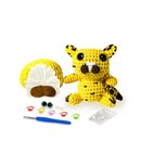 Crocheted animal toy with yarn, hooks, and tools on a white background