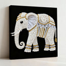 Decorative elephant wall art with pearls and gold accents on a black background