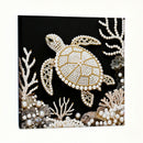 Decorative panel with a turtle design made of pearls and beads on a black background