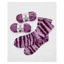 Two skeins of purple yarn with striped socks on a white background
