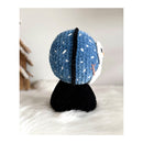 Side View of Crocheted amigurumi with blue and white pattern on a white surface