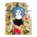Hand holding a crocheted snowman amigurumi with a Christmas tree in the background