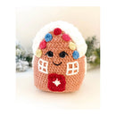 Crocheted gingerbread houseamigurumi with colourful decorations on a blurred snowy background