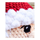 Close-up of a red, white, and beige textured amigurumi with a embodied black eye