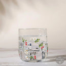 Clear glass tumbler with floral design on a light background