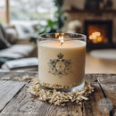 Candle with decorative label on a wooden table in a cozy room with a fireplace.