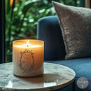 Candle with decorative design on a marble table in a cozy indoor setting
