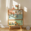 Wooden cabinet with Winnie the Pooh design on drawers, placed against a light wall.