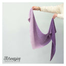 Person holding a purple knitted shawl against a light gray background with 'Scheepjes' branding.