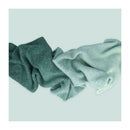 Two green textured cloths on a light blue background