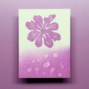 Notebook with a purple flower design on a light green cover against a purple background