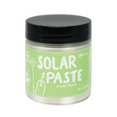 Jar of solar paste with a green label and black lid on a white background