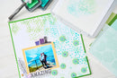 Scrapbooking project with patterned paper, photo, and crafting tools on a white surface