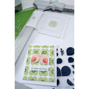 Card with floral design and text 'It's been too long' next to a die-cutting machine.