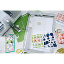 Card-making tools and designs on a white surface