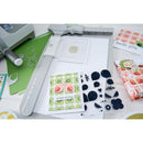 Card-making supplies including stamps, dies, and printed cards on a white surface.