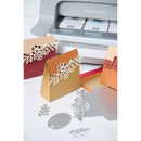 Cardboard boxes with laser cut designs in front of a Big Shot Plus machine.