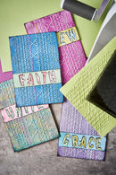 Colorful textured cards with embossed text on a wooden surface