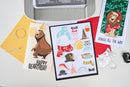Card with bear illustration and birthday text, surrounded by stationery items on a light gray background.