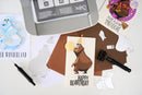 Birthday card with bear illustration and printer on a table
