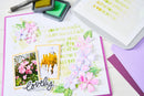 Card with floral design and text, surrounded by stamping tools on a white background