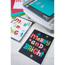 Colorful 'Merry and Bright' greeting cards with a printer in the background.