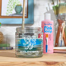 Jar of Silicool and pink bottle of Speedball Pink Soap on a wooden surface with brushes in the background.